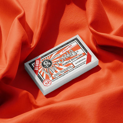 Pack of blood orange fabric dye placed on a vibrant orange fabric background