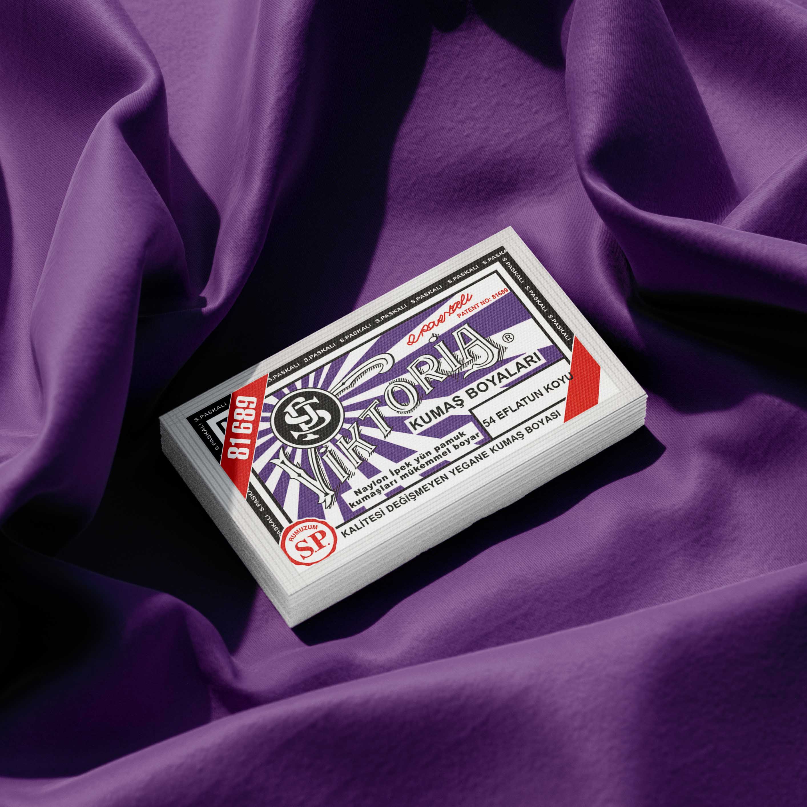 Pack of lilac fabric dye placed on a vibrant purple fabric background